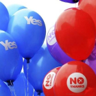 Partidarios del Sí y del No sujetan globos con distintos mensajes de cara al referéndum en Glasgow, ayer.