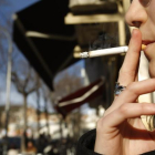 Una mujer fuma en la calle. /