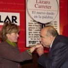 Lázaro Carreter besa la mano de la ministra antes de presentar su libro