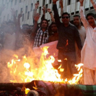 Manifestantes queman una imagen de la líder de facto de Birmania, Aung San Suu Kyi, durante una protesta contra la persecución de los rohinyas, en Karachi (Pakistán), el 17 de septiembre.