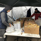 Dos voluntarios preparan bolsas con productos enlatados. GERVASIO SÁNCHEZ