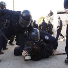 Agentes de la policía de Oakland arrestan a uno de los participantes en la protesta de indignados, el sábado, en el centro de la ciudad.