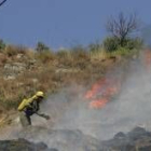 Dos trabajadores forestales apagan un incendio en la comarca, en una imagen de archivo