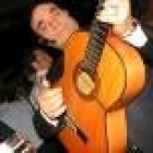 Manuel Quijano padre tocando la guitarra de pie, como a él le gusta