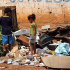 Dos niños buscan entre la basura en Brasilia, Brasil.