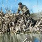 Uno de los colaboradores de la escuela, en plena labor de desbroce en la zona del río