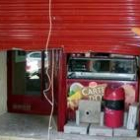 Un operario repara la persiana metálica del establecimiento robado