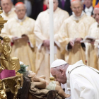 El papa besa los pies a la figura del niño Jesús, ayer.