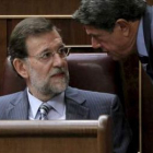 Rajoy conversa con Federico Trillo durante la sesión de control al Gobierno.