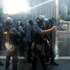 Agentes antidisturbios lanzan agua contra los manifestantes en la avenida Paulista, en Sao Paulo, este viernes.