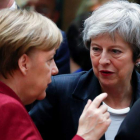 La canciller alemana Merkel conversa con la primera ministra británica, May. OLIVIER HOSLET
