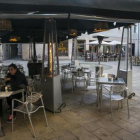 Dos personas en una terraza con estufas.