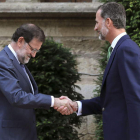 Rajoy y el rey se saludan en su encuentro de ayer en el Palacio de Marivent.