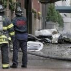 Dos bomberos observan los restos de la aeronave que se estrelló contra un inmueble en Nueva York