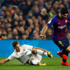 El delantero uruguayo del FC Barcelona, Luis Suárez, se lleva el balón ante el centrocampista del Real Madrid, Marcos Llorente.