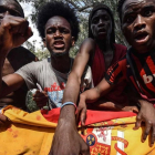 Un grupo de inmigrantes que entraron en Ceuta tras saltar la valla sostienen una bandera española. /
