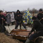 Varias personas asisten al funeral de uno de los fallecidos en el bombardeo de Mariúpol.