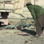 Un hombre contempla los restos de la bicicleta bomba que ayer acabó con la vida de quince personas