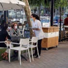Varias personas en una terraza de un bar de Madrid, atendidos por una camarera. EMILIO NARANJO