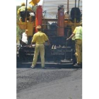 Unos obreros trabajan en el asfaltado de una carretera del Estado