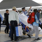 Un pasajero herido al suicidarse un individuo en un tren bala japonés es trasladado por los equipos de emergencia.