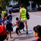Unos voluntarios acompañan a la escuela a niños refugiados en la isla griega de Chios.