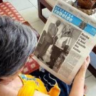Una mujer lee el diario en el que aparece la foto del encuentro