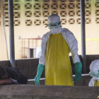 Personal sanitario liberiano se prepara para recoger el cuerpo de una víctima, ayer.