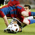 Messi pelea un balón con el defensa del Valencia Costa.