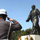 Dos guardas de seguridad saludan a la estatua del fallecido líder chino Deng Xiaoping.