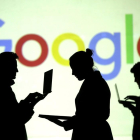 Siluetas ante el logo de Google.