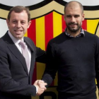 Rosell (i) estrecha la mano de Guardiola, tras renovar.