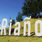 El mirador del Alto de Vacayo y las letras que en la falda de la loma de la iglesia nombran a Riaño. DL