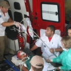 Un menor es llevado herido en una ambulancia.