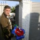 Un vecino de la familia muestra algunos juguetes del bebé en la puerta de su casa