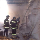 Varios bomberos en un momento de los trabajos de extinción dentro de la explotación.