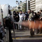 Policías antidisturbios disparan gas lacrimógeno, ayer, durante los enfrentamientos con jóvenes