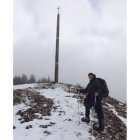 Marco posa a los pies de la Cruz de Ferro y Laura camina sobre la nieve. WWW.2CUORINCAMMINO.IT