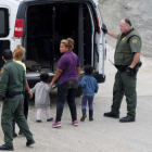 Oficiales de fronteras detienen a una mujer y su hijo integrantes de la caravana de inmigrantes de Centro América.