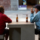 Varias personas se toman una cerveza en un banco de una calle del centro de Barcelona. ALEJANDRO GARCÍA