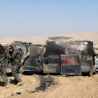 Dos ‘peshmergas’ observan un vehículo calcinado que supuestamente perteneció al EI. AHMED JALIL