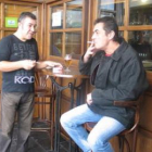 El camarero y un cliente de un bar de Bembibre, fumando en la calle, a las puertas del local.