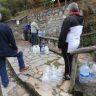 Vecinos de Fabero cogen agua potable en la fuente del Cangalón, en una foto reciente. L. DE LA MATA