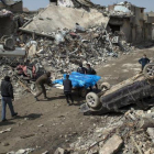 Unos civiles retiran cadáveres de entre las ruinas de Mosul.