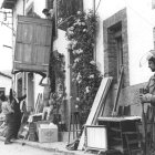 Un policía vigila mientras una familia desaloja los enseres de su vivienda, hace 30 años. CÉSAR