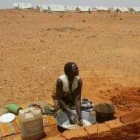Una sudanesa refugiada lava su ropa   cerca de unas tiendas de campaña en el Chad