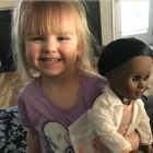 La pequeña Sophia, de 2 años, con su muñeca negra.