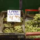Un frutero muestra un racimo de uvas en un mercado de Madrid este viernes. JUAN CARLOS HIDALGO