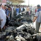 Varios iraquíes inspeccionan el sitio donde explosionó el coche