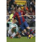 Messi intenta escaparse de un rival verdiblanco en el partido de ayer